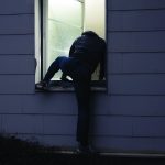 Male Criminal Climbing Thru Window