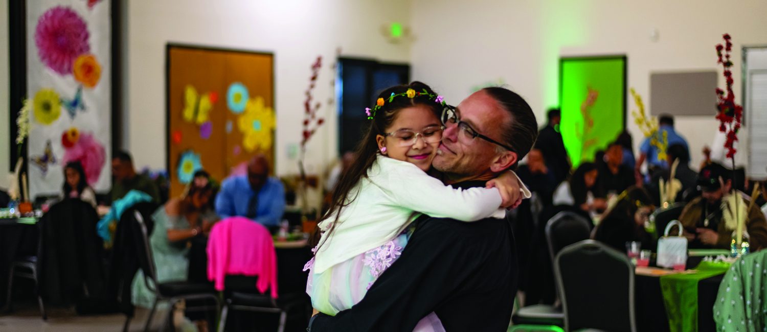 Father holds daughter at father-daughter dance